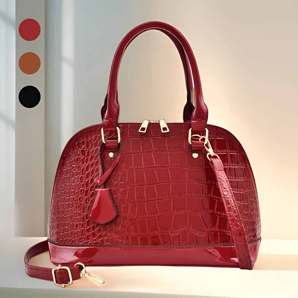 Shiny black PU leather crossbody bag with a structured shell shape, shown with a shoulder strap.
