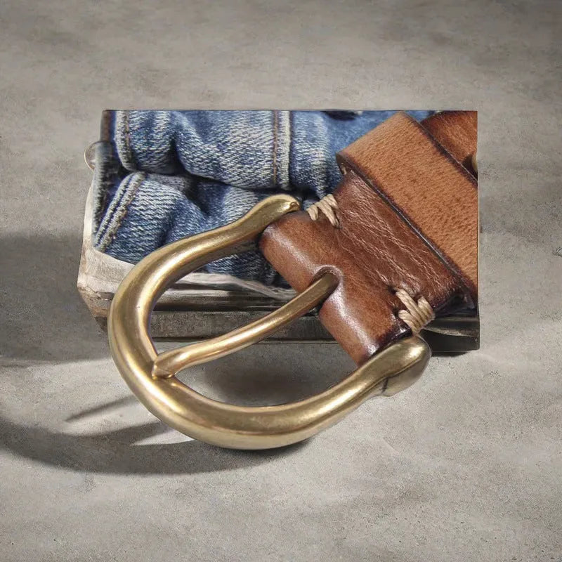 Men's black casual leather belt with a copper pin buckle on a jeans background.