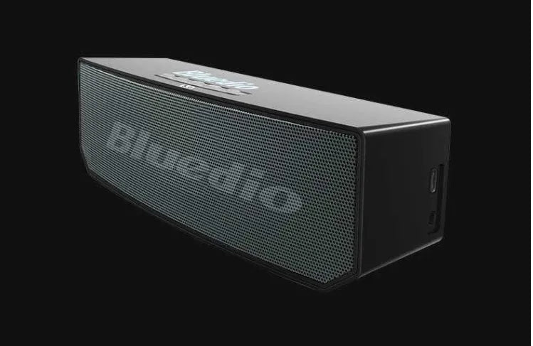 Black Bs-6 Bluetooth smart speaker on a desk showing its compact rectangular form.