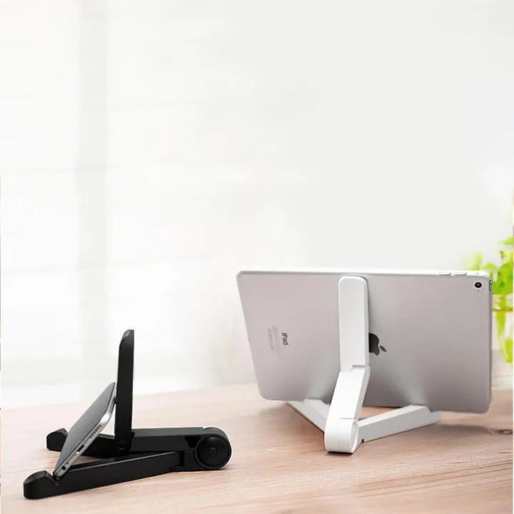 Black foldable tablet holder open on a table, holding a smartphone in landscape mode.