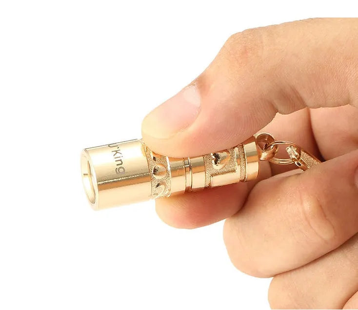 Gold zinc alloy mini LED keychain flashlight with a waterproof case and emergency light function.