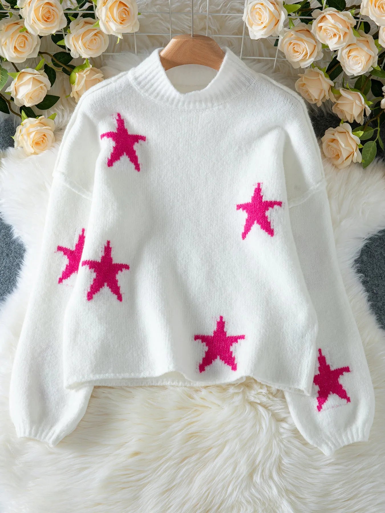 White women's loose turtleneck sweater with a large black five-pointed star pattern on the front.