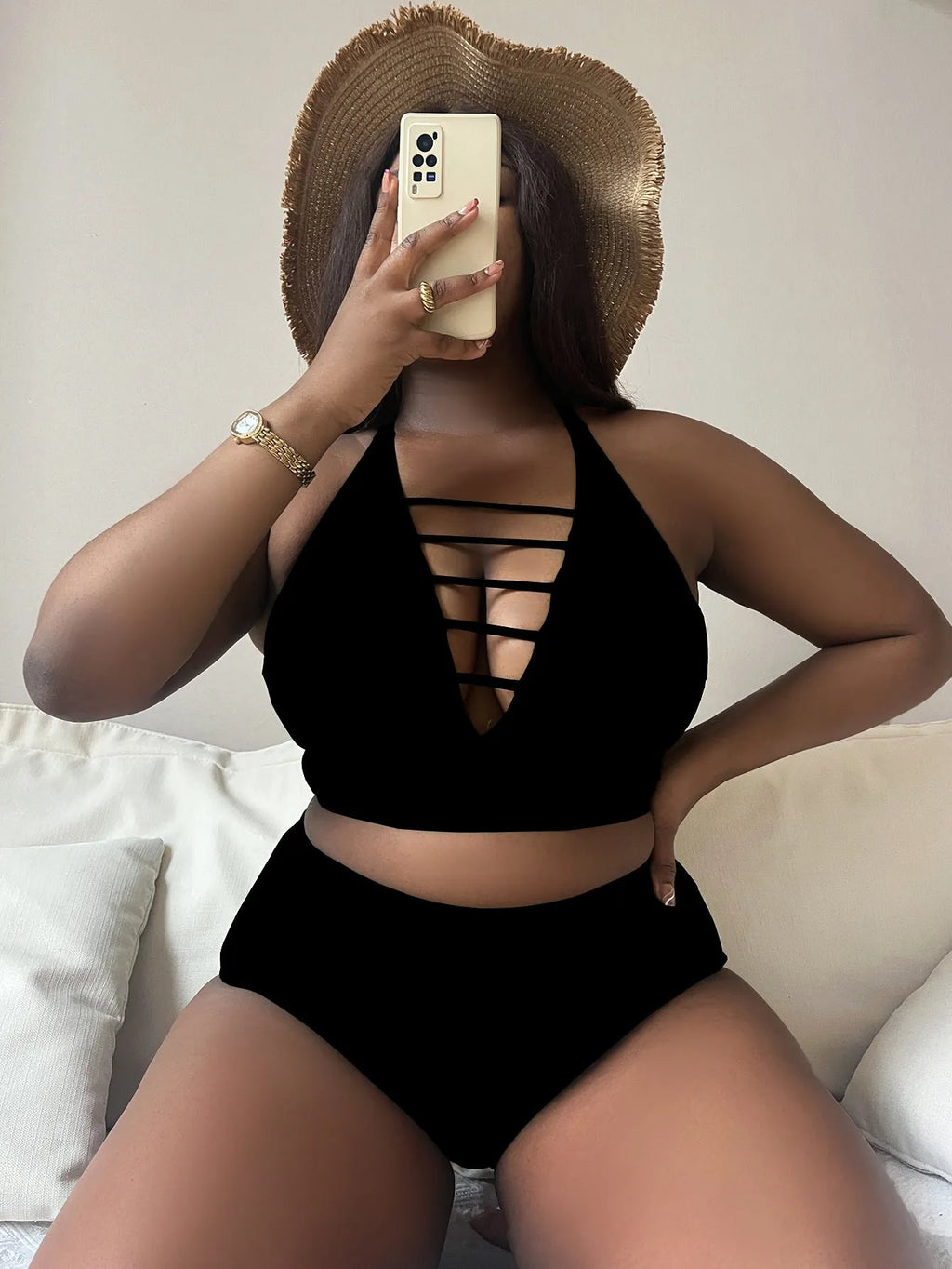 Plus size woman modelling a black halter neck bikini with cross-back straps and high-waisted briefs.