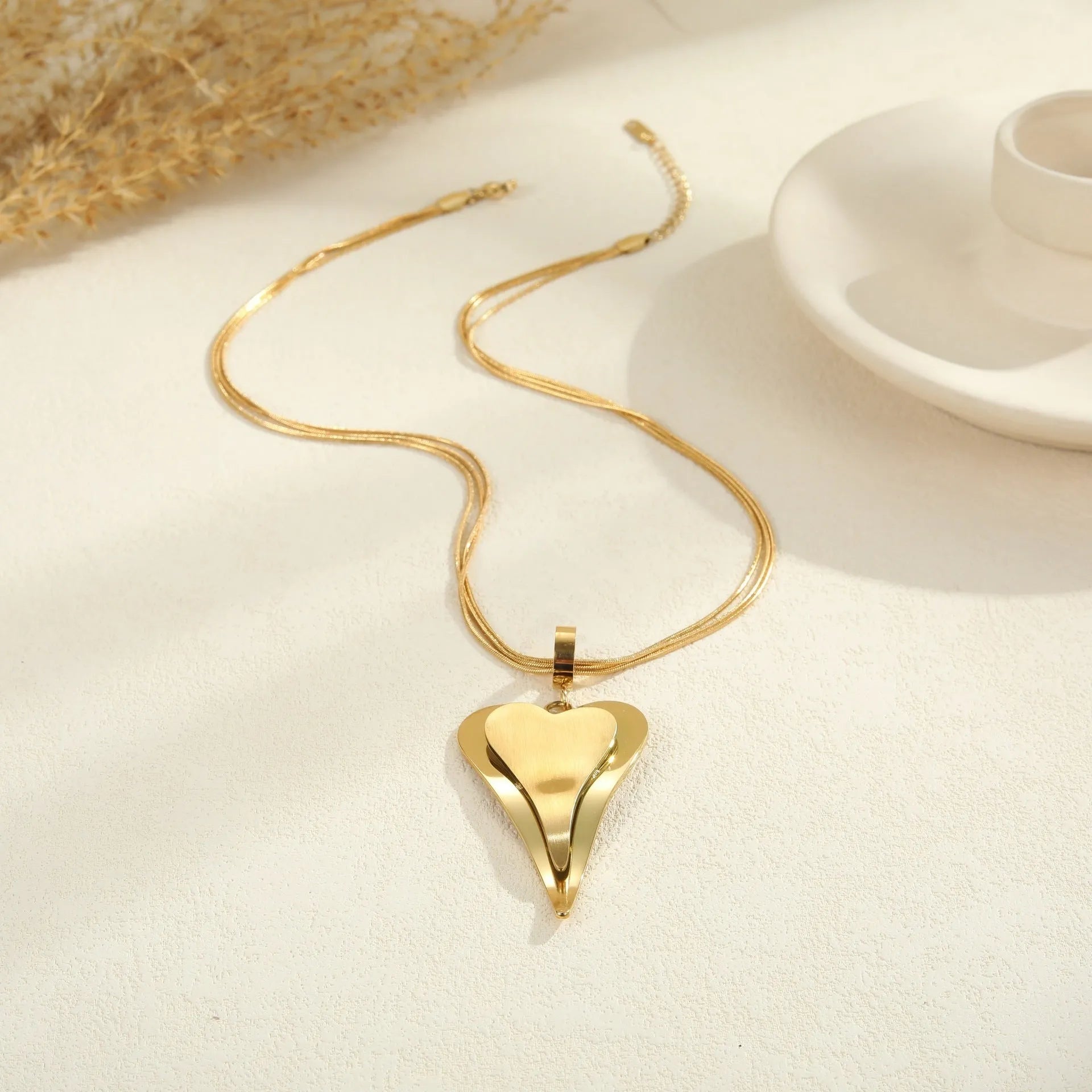 Stainless steel women's necklace with double heart geometric pendant on a snake bones chain.