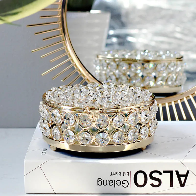 French gold iron jewellery box with a clear crystal glass lid on a wooden surface.