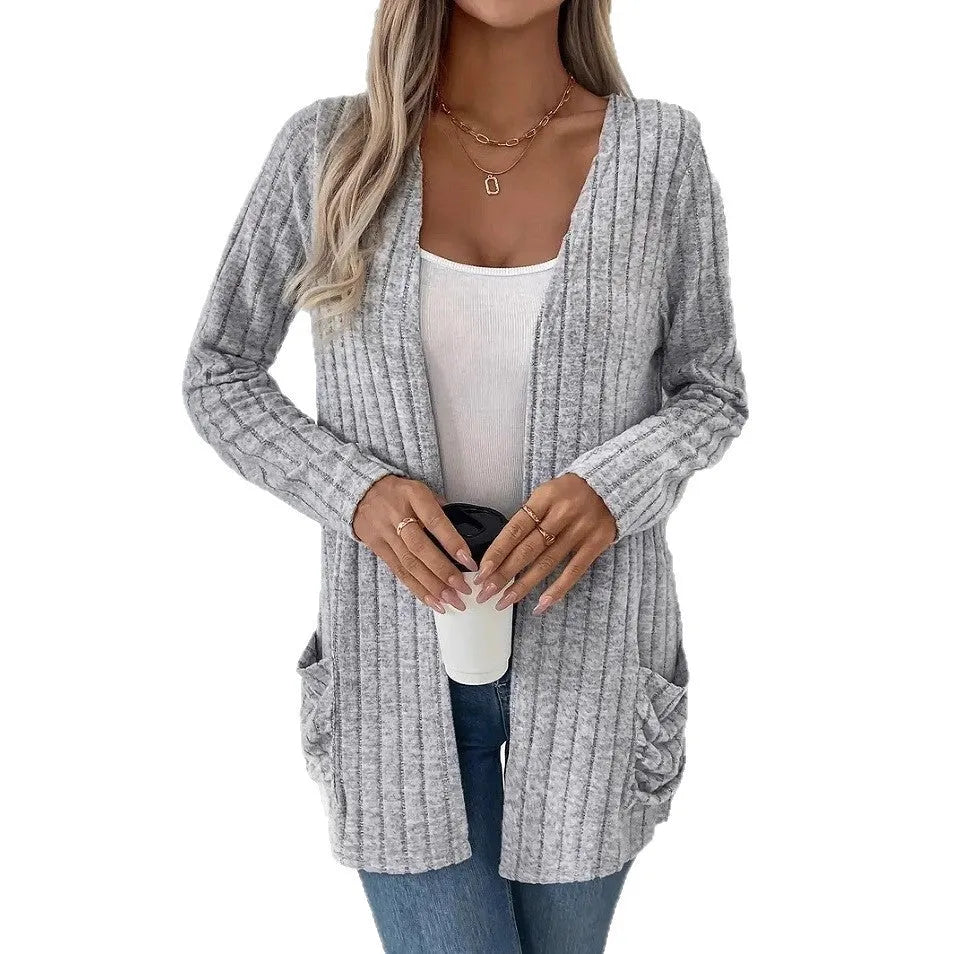 Long sleeve loose fit cardigan in grey with a pocket, shown on a hanger.