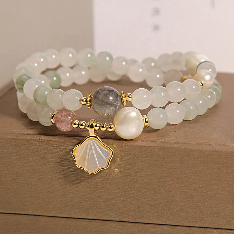 Women's crystal bracelet with a large green ginkgo leaf pendant, gold metalwork, and sparkling rhinestones.