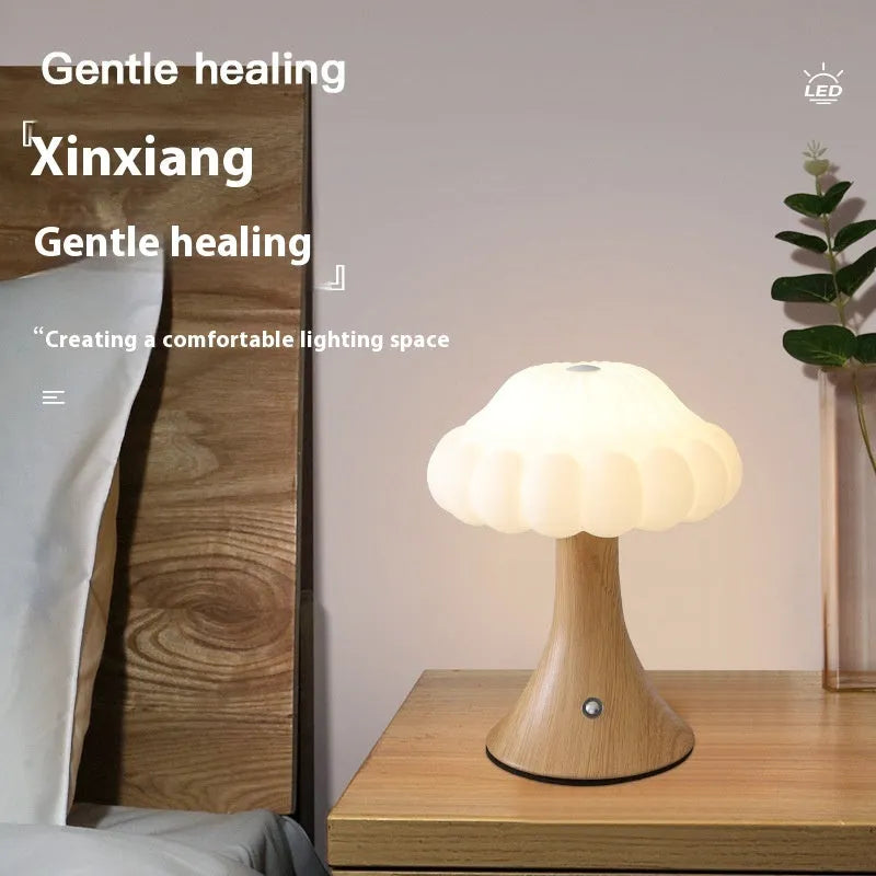 Small decorative mushroom-shaped night lamp on a surface, showcasing its USB charging port and touch control.