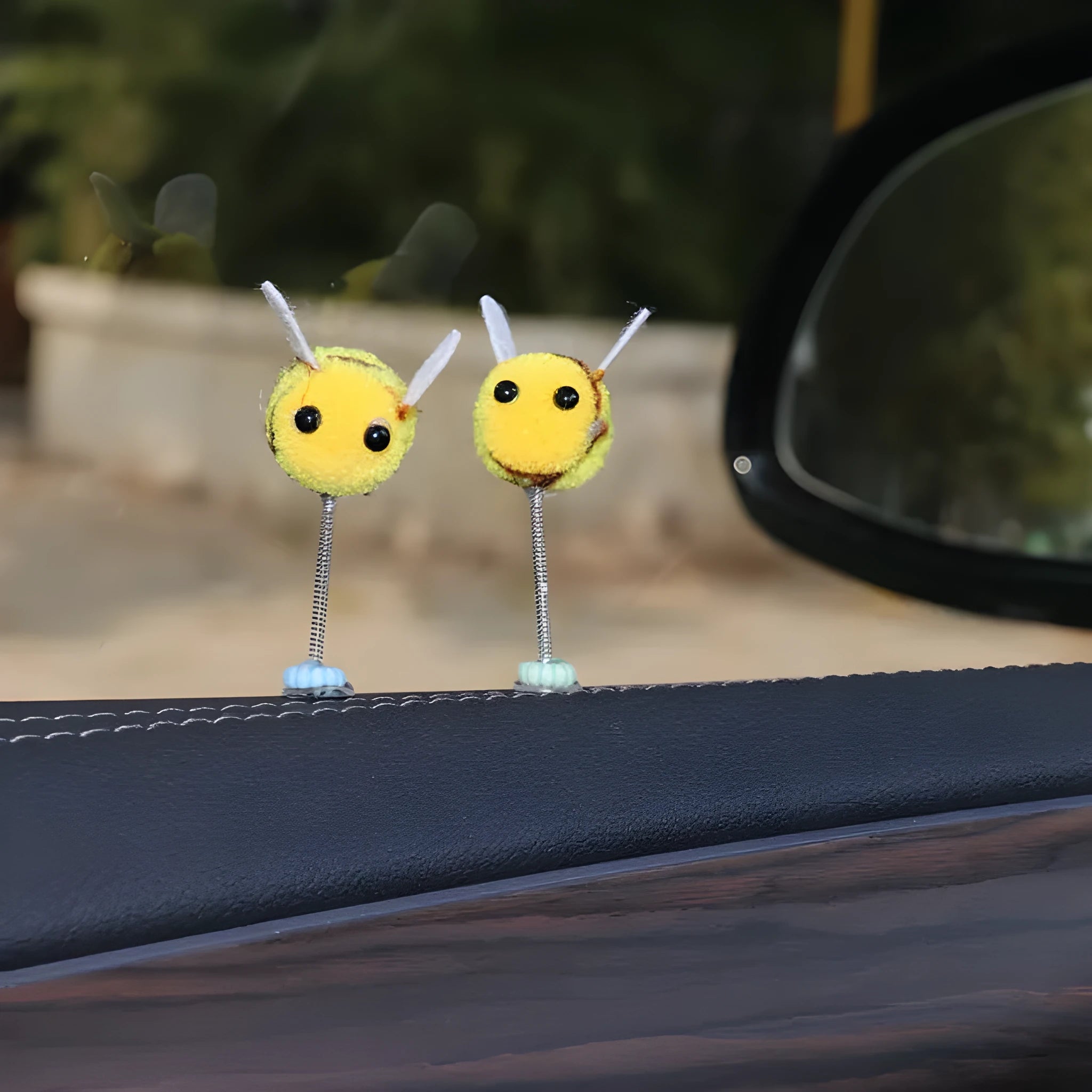 Small, soft, cartoon bee car decoration made from yellow and black fur ball material.