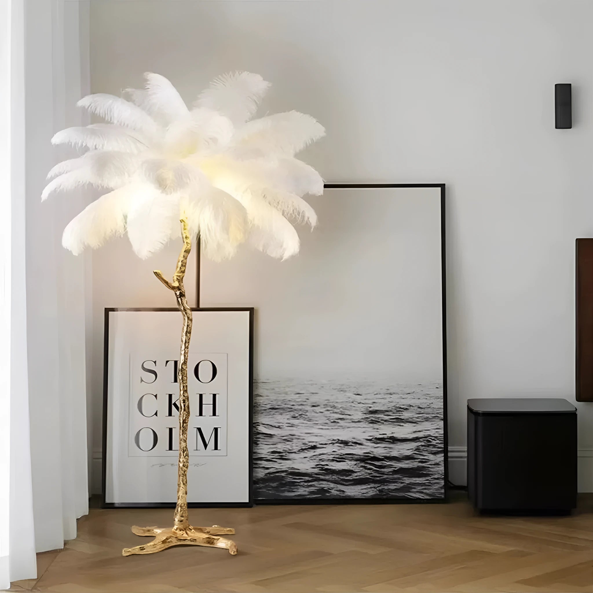 Tall decorative floor lamp with many white resin feathers and a dark base on a wooden floor.