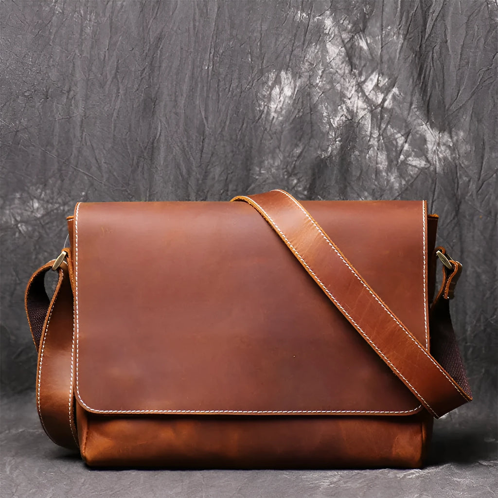 Vintage brown men's leather messenger bag showing interior compartments and adjustable shoulder strap