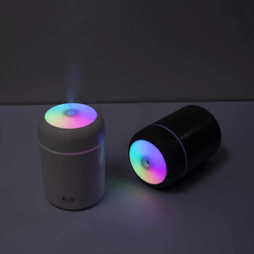 Pink USB portable humidifier with 300ml tank and colourful lights on a desk