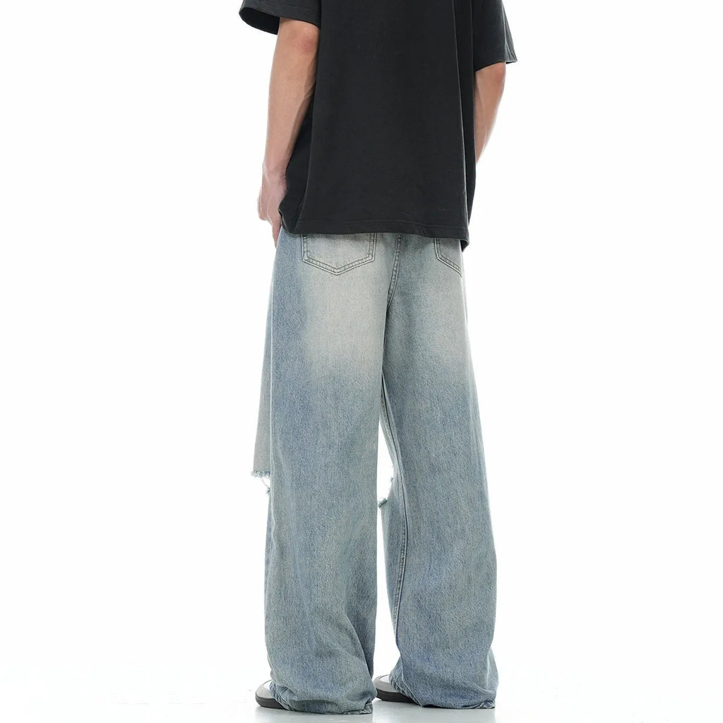 Blue men's straight-leg jeans with ripped details and a zipper fly, showing retro style.