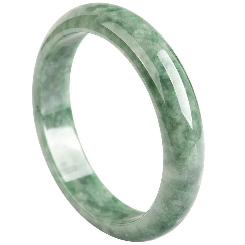 Natural emerald green jade bracelet on wrist, showing simple band style and deep pea green stone colour.