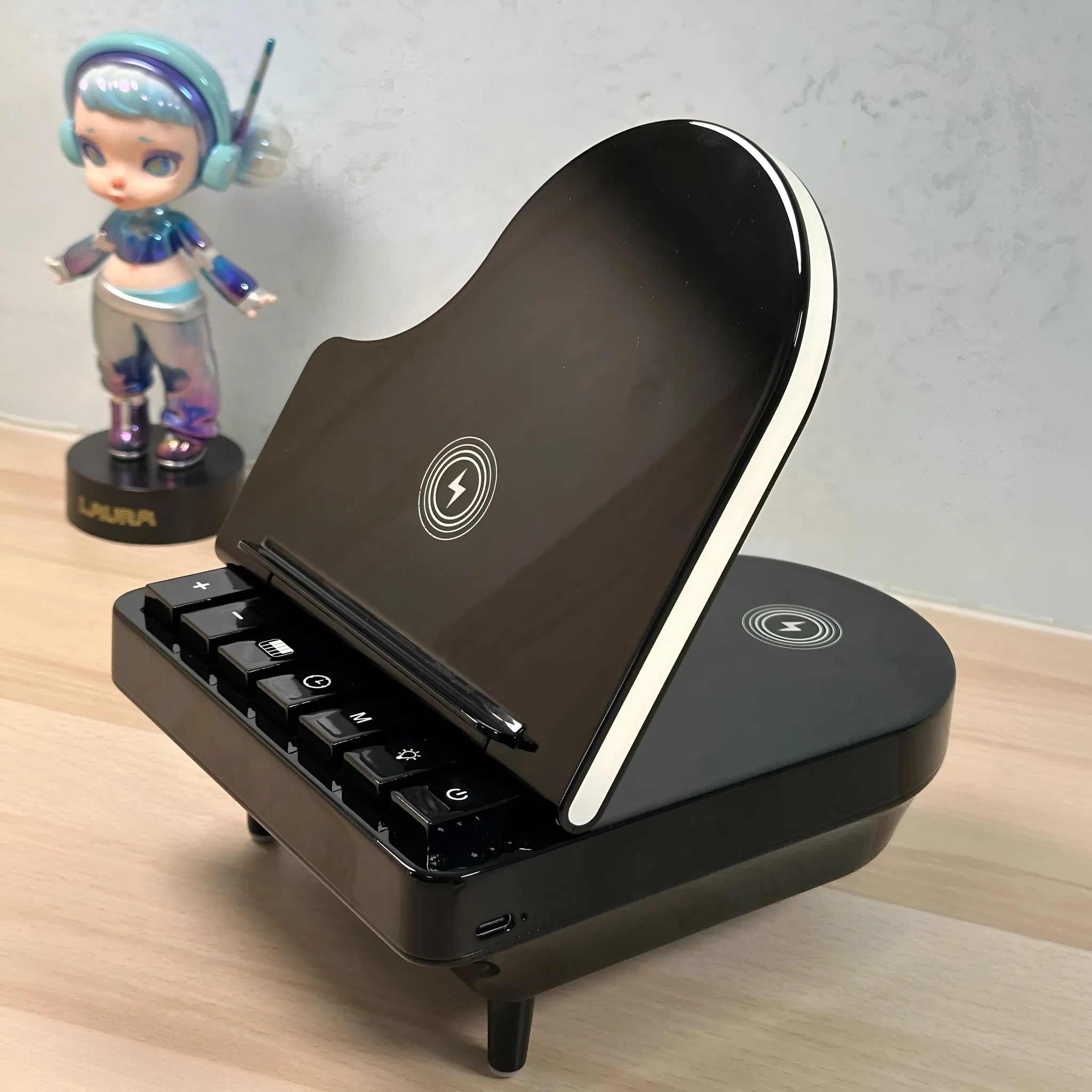 Black 3-in-1 Bluetooth speaker with wireless charger and phone holder on a desk