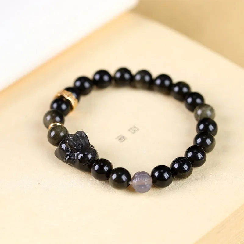 Handmade national style bracelet with a lying rabbit charm, grey agate, and metal details on a wrist.