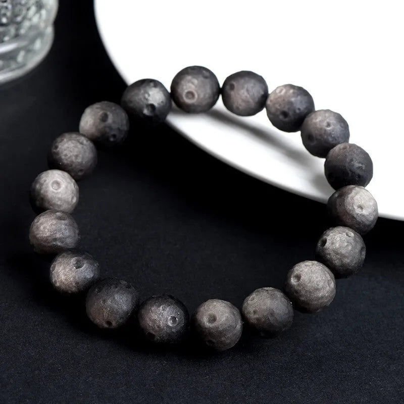 Natural obsidian crater ball bracelet in silver stone or gold finish, showing textured bead detail.