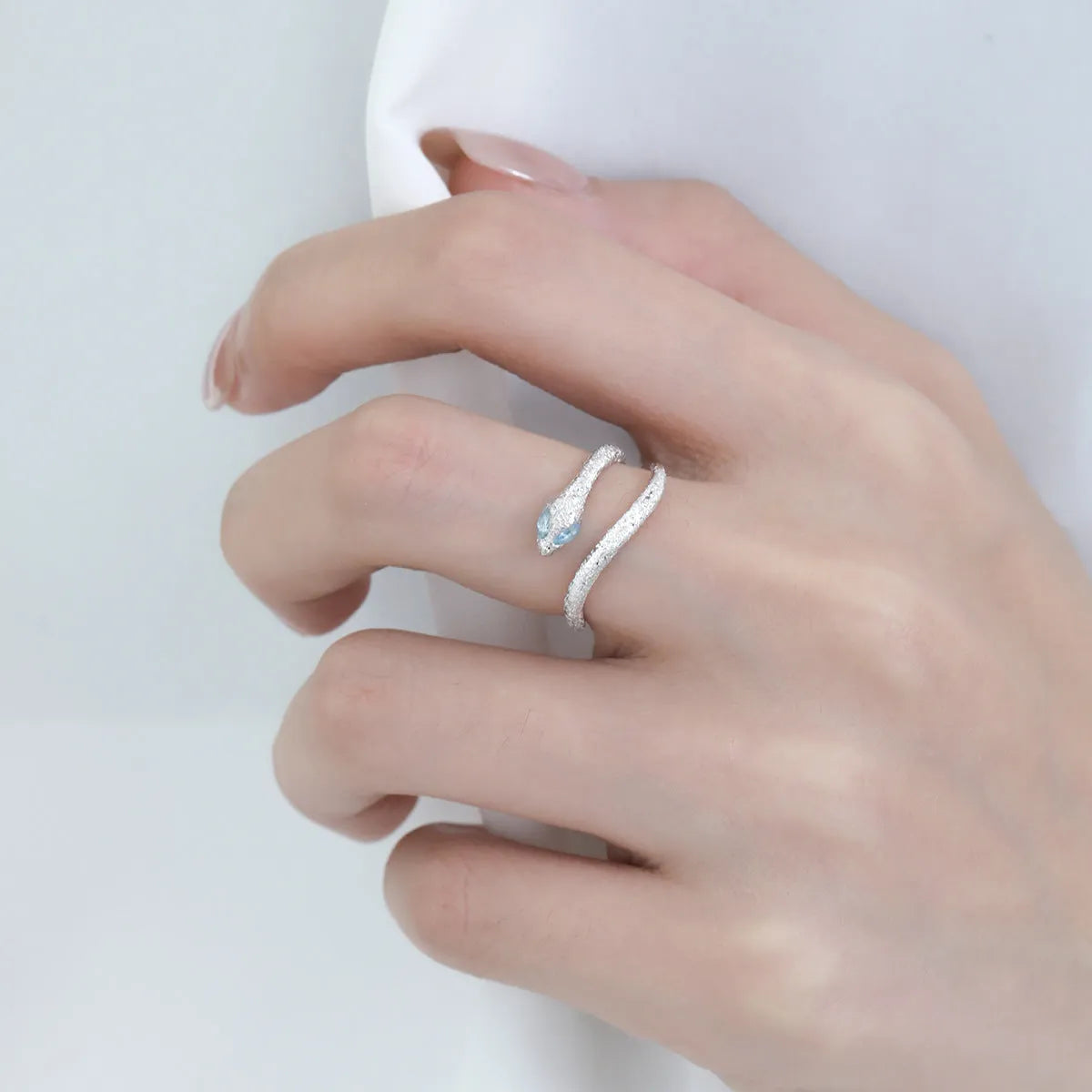Silver adjustable snake ring with platinum colour finish on a white background