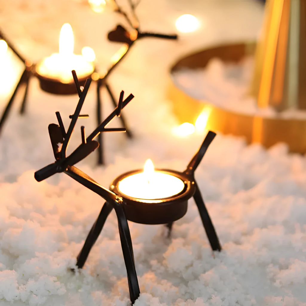 Black iron Christmas candlestick holder with decorative elk design on a festive table.