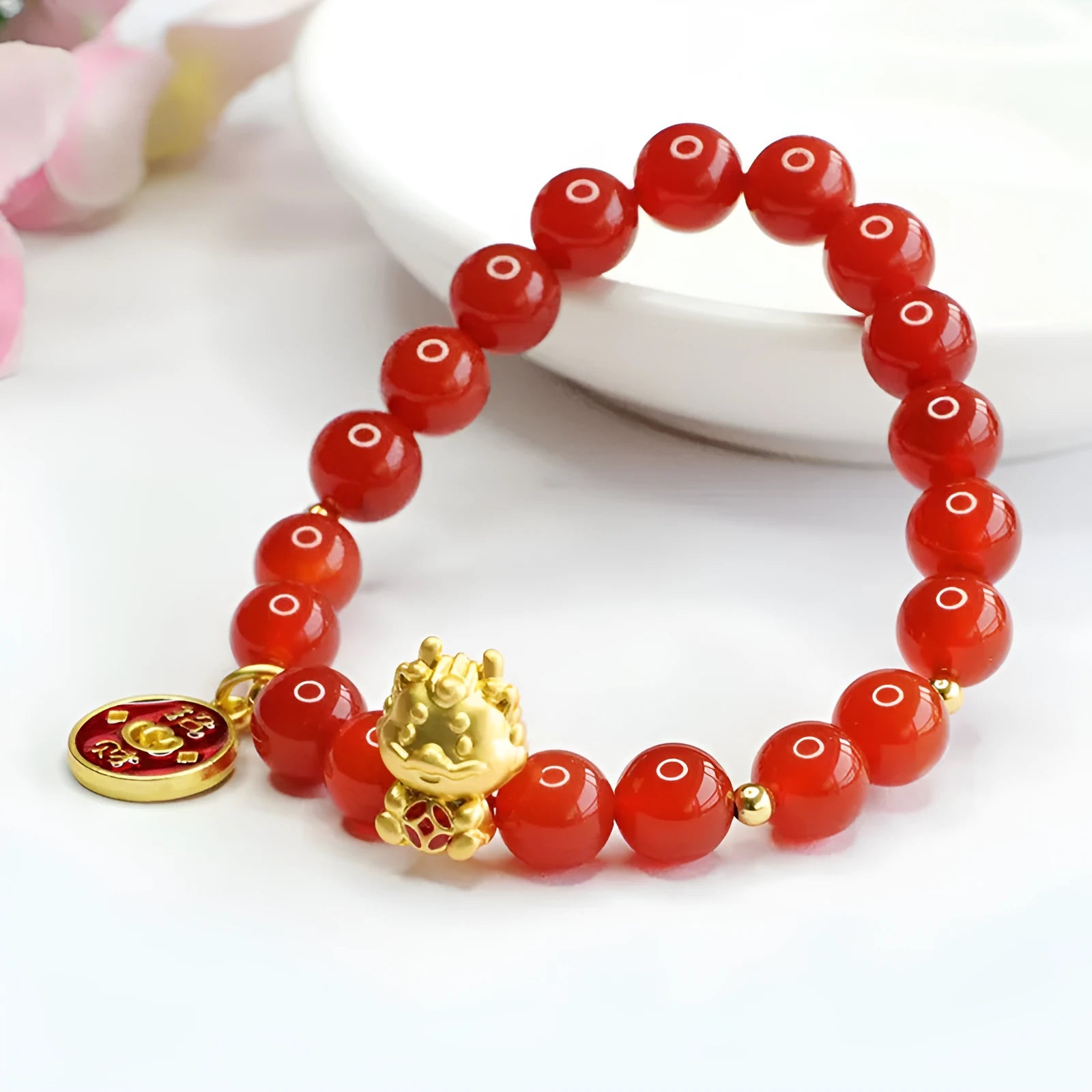 Close-up of a Chinese zodiac dragon bracelet with 8mm red agate beads on a wrist.