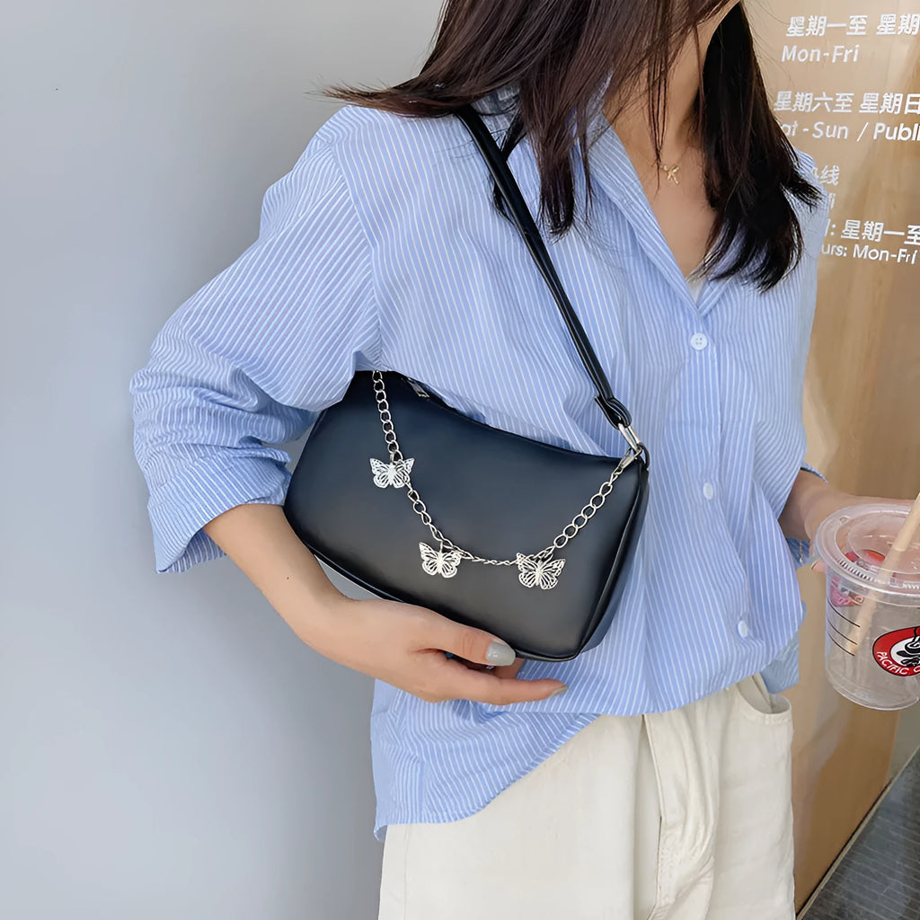 Women's black PU leather butterfly chain crossbody bag with convertible strap showing internal organisation compartments