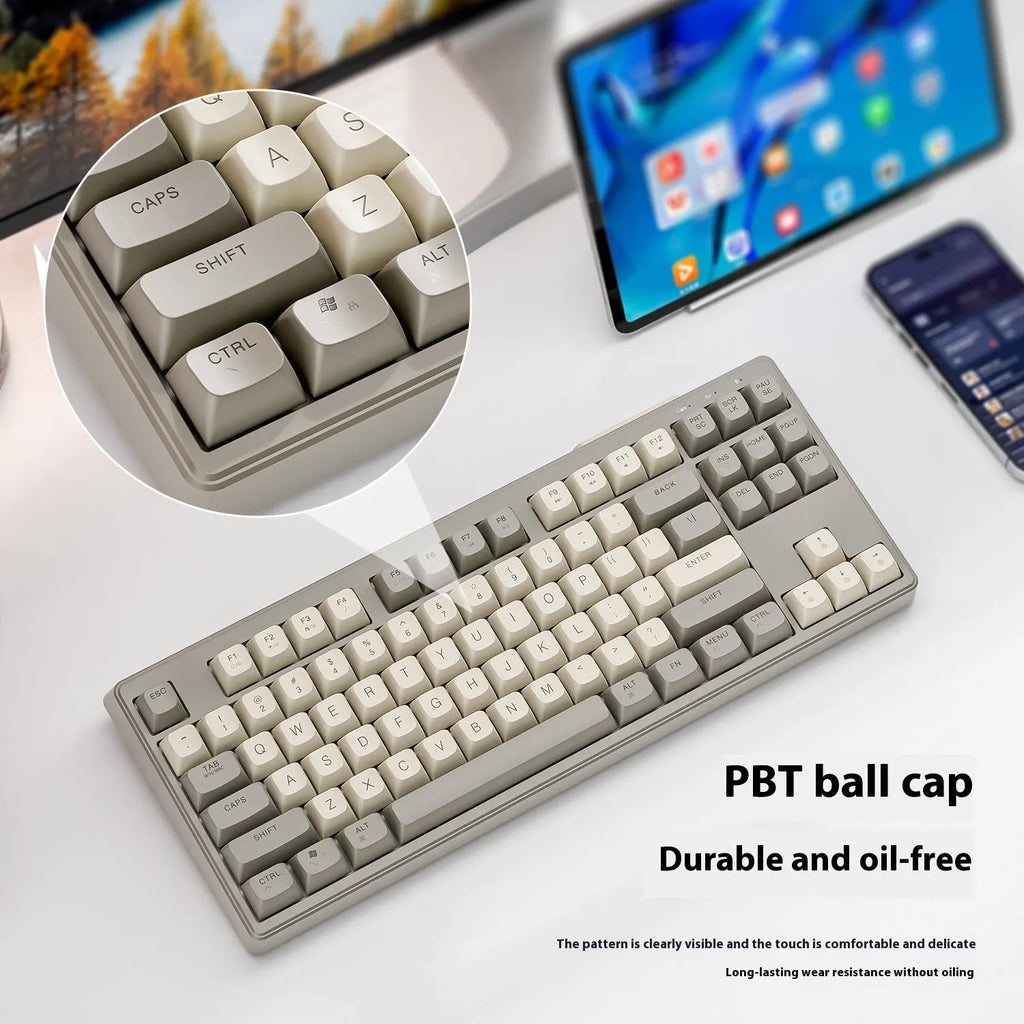 Free Wolf M87 wireless Bluetooth dual-mode mechanical feel keyboard in one of four colour options on a desk.