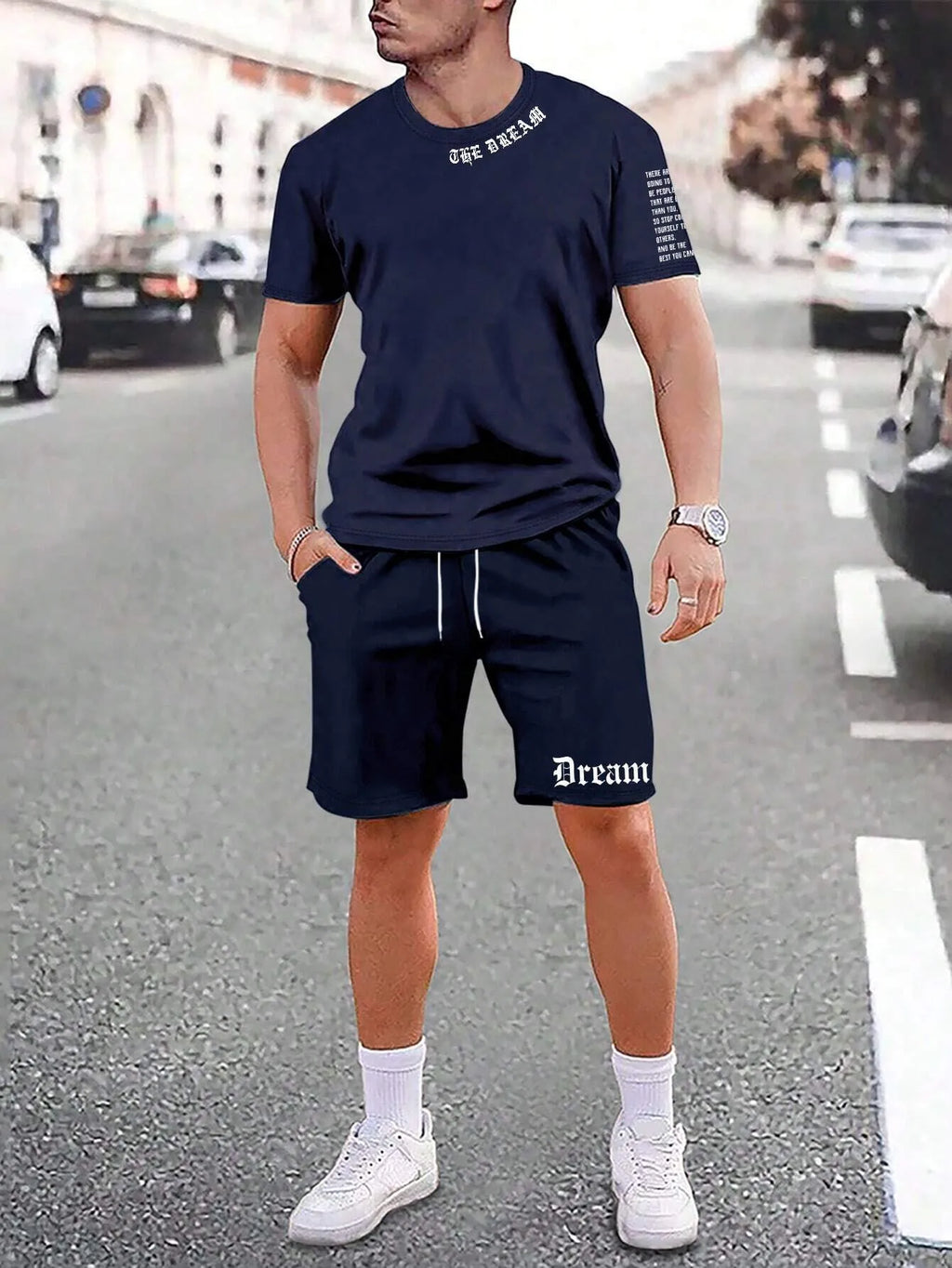 Man wearing a blue printed short-sleeve top and matching shorts from a two-piece sports casual set.