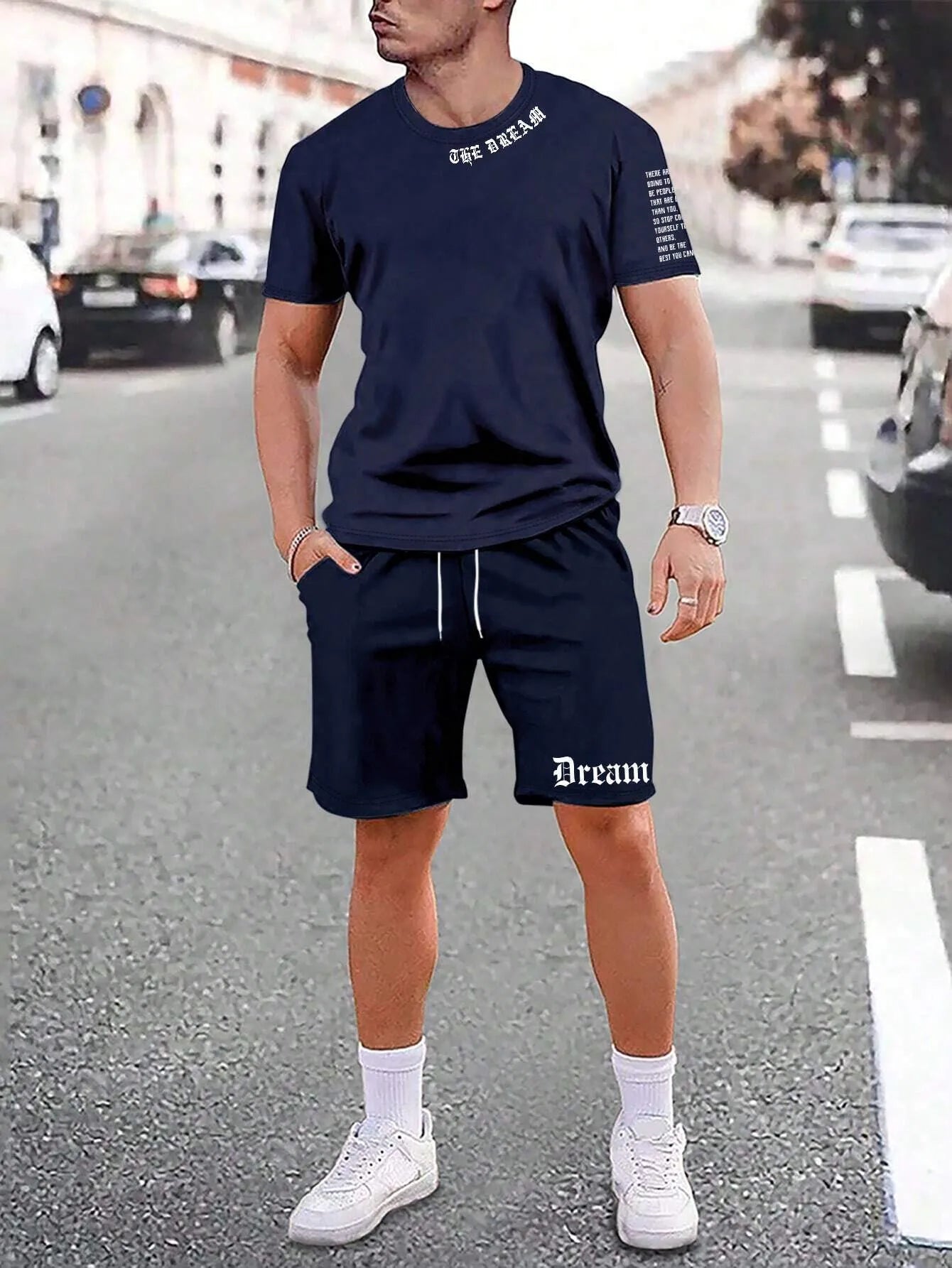 Man wearing a blue printed short-sleeve top and matching shorts from a two-piece sports casual set.