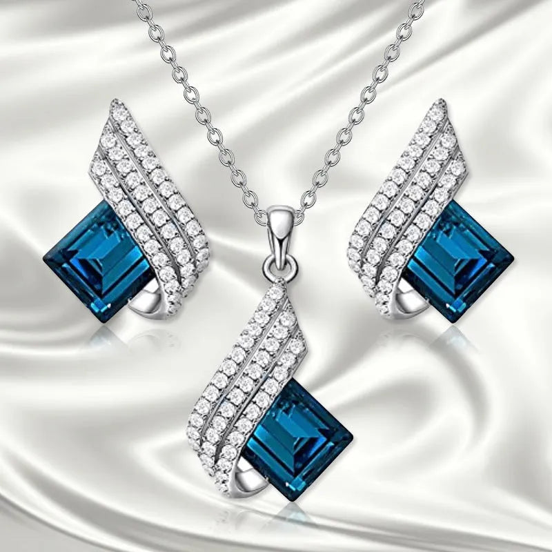 Women's jewellery set showing necklace with cross chain and matching earrings with glass elements