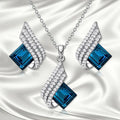 Women's jewellery set showing necklace with cross chain and matching earrings with glass elements