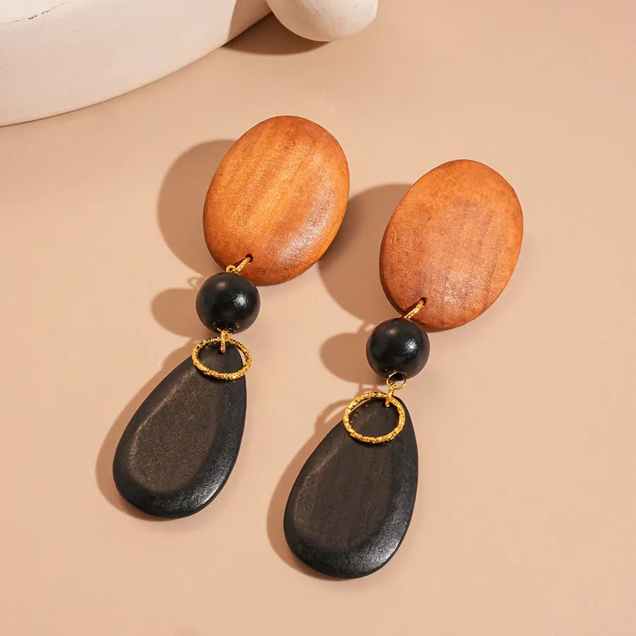Wooden retro earrings with silver brown black colour scheme and elliptical design elements