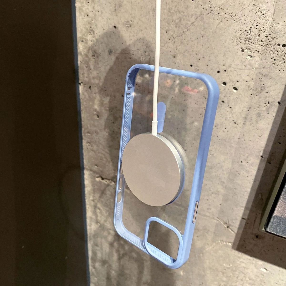 Transparent acrylic MagSafe phone case for iPhone on a table, showing magnetic ring and colour options.