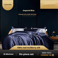 Solid colour silk quilt cover and pillowcases from a four-piece bedding set in a champagne gold hue on a bed.