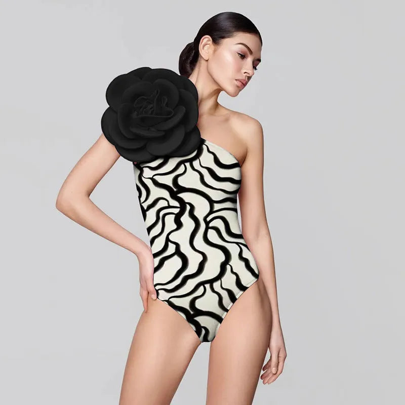 Women's one-piece swimsuit with three-dimensional floral design on black fabric.