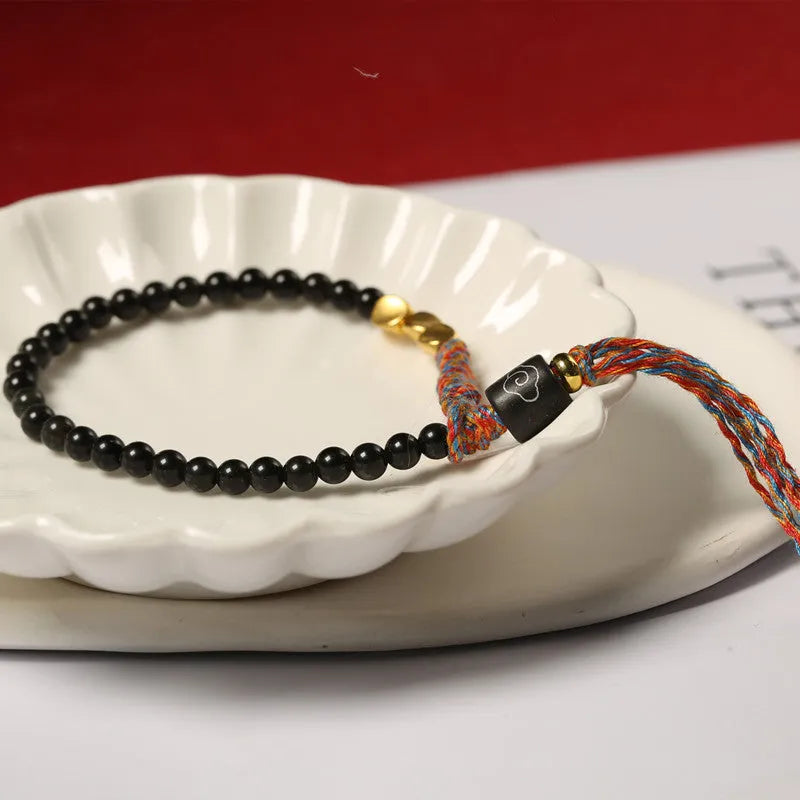 Hand-woven obsidian carrying strap bracelet with textured finish on wrist