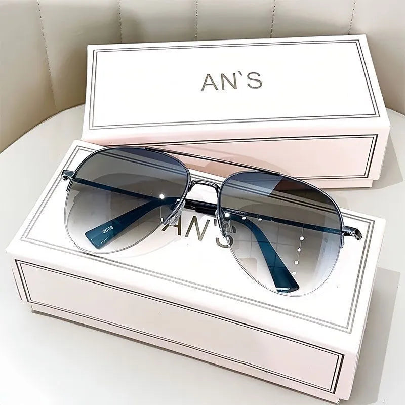 Aviator-style sunglasses with a metal frame and tinted resin lens, shown in a gold frame variant.