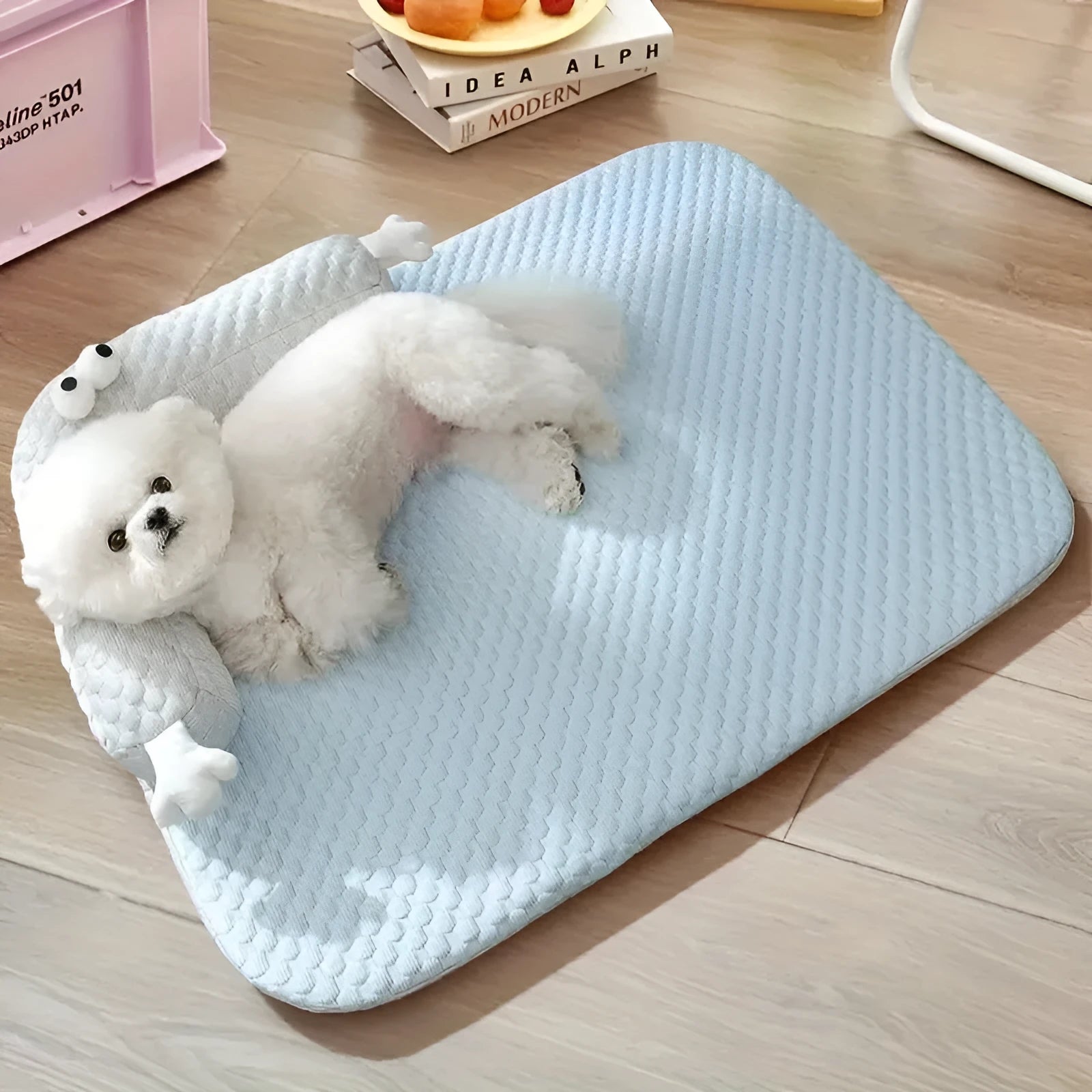 Blue big-eyed monster design pet bed for dogs and cats on a wooden floor.