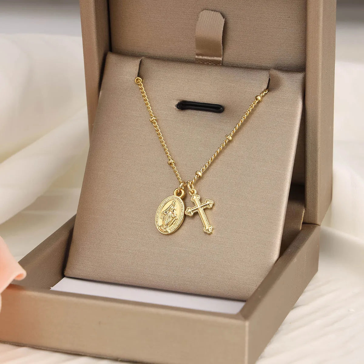 Geometric Virgin Mary and cross pendant necklace in 18K gold colour on a copper chain.