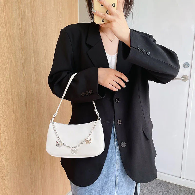 Women's black PU leather butterfly chain crossbody bag with convertible strap showing internal organisation compartments