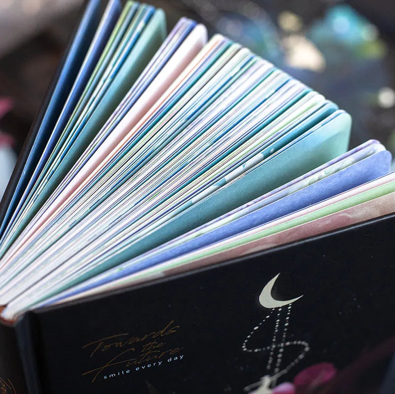 A5 size notebook with a luminous cover, open to show colour illustration pages and lined 160gsm paper.