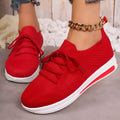 Women's low-top fly-knit sneakers in red with round toe and lace-up front.