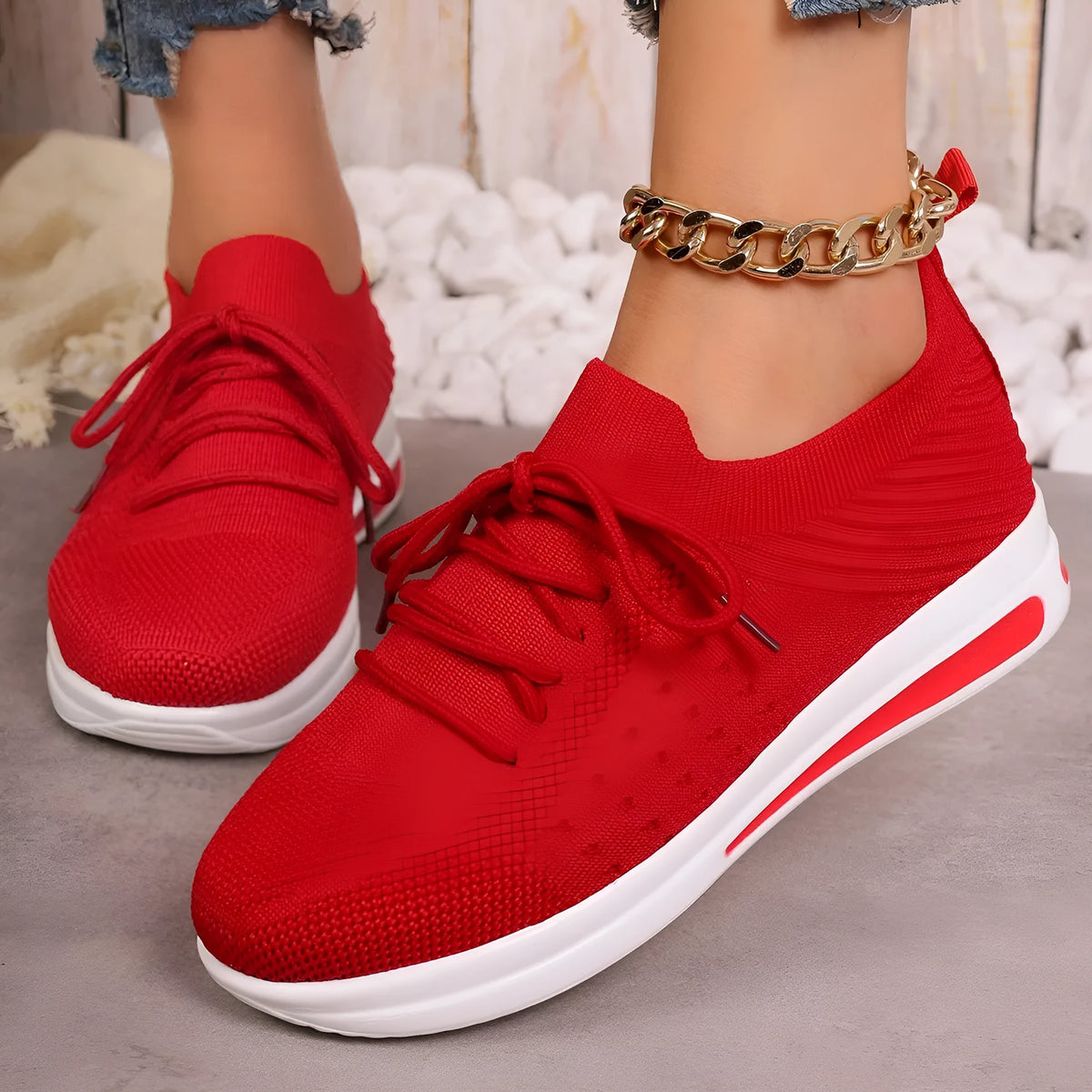 Women's low-top fly-knit sneakers in red with round toe and lace-up front.