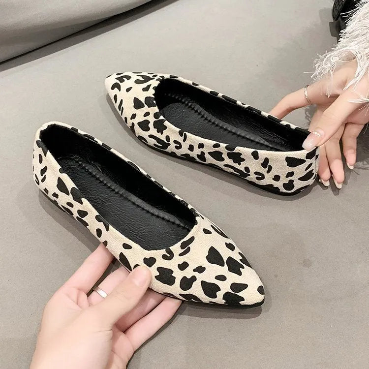 Women's flat pointed toe leopard print pumps with a low heel on a plain background.