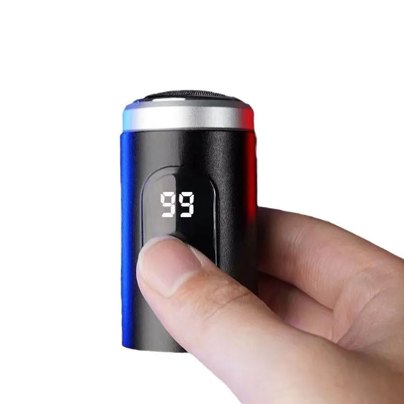 Black portable USB rechargeable shaver with cleaning brush and cable on a table.