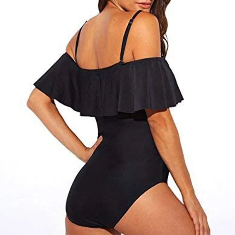 Black one-piece swimsuit with side cut-out detail and ruffled tube top straps.