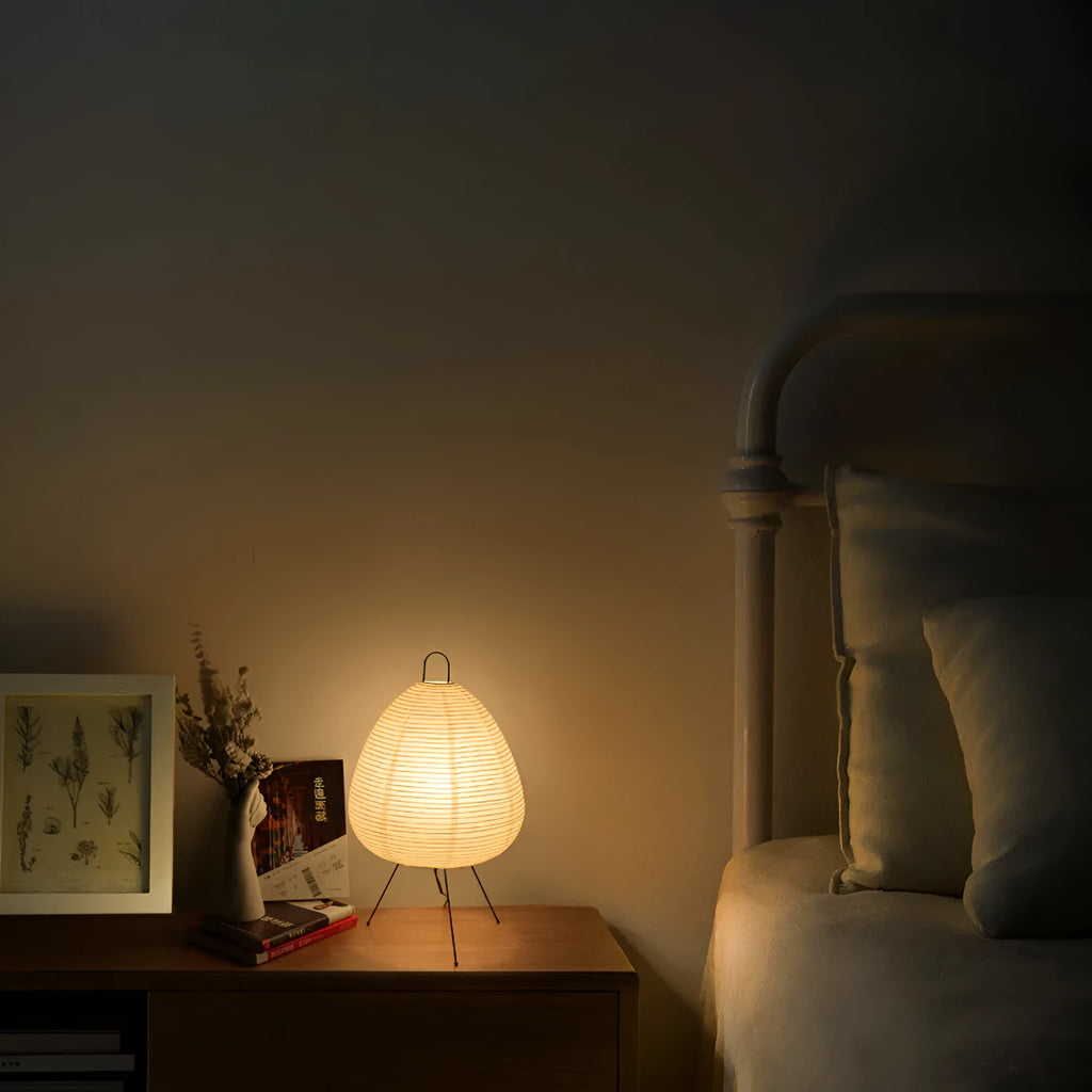 Nordic style table lamp with a handmade Japanese rice paper shade and aluminium base on a wooden table.