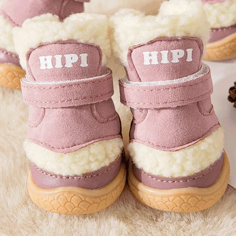 Brown winter dog shoes with adjustable Velcro straps and anti-slip rubber soles on a snowy surface