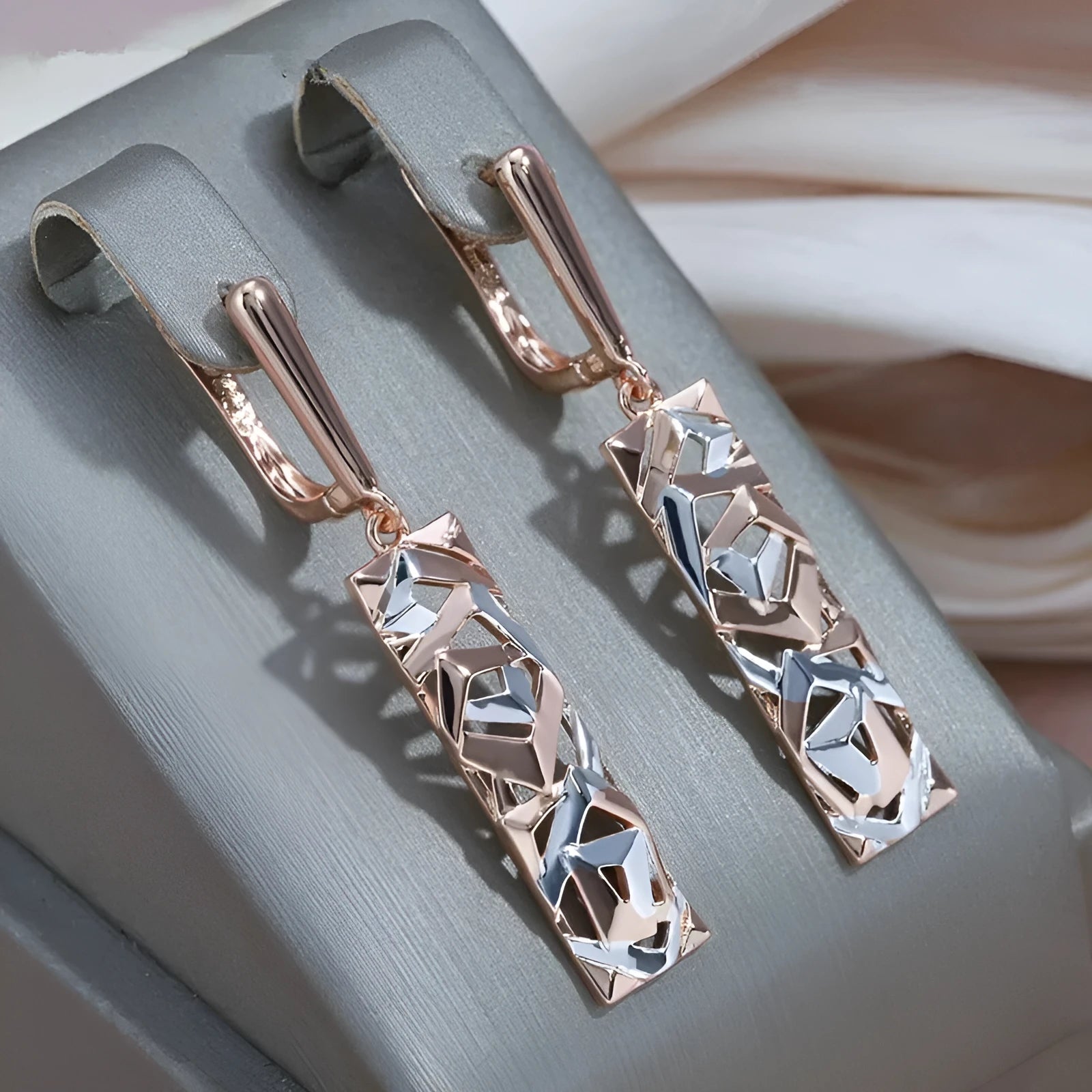 A pair of rectangular two-tone hollow stud earrings with a geometric shape and electroplated finish.