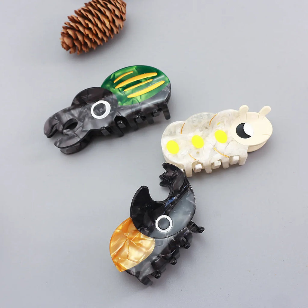 Handmade green and orange cellulose acetate beetle grip with white caterpillar cartoon design