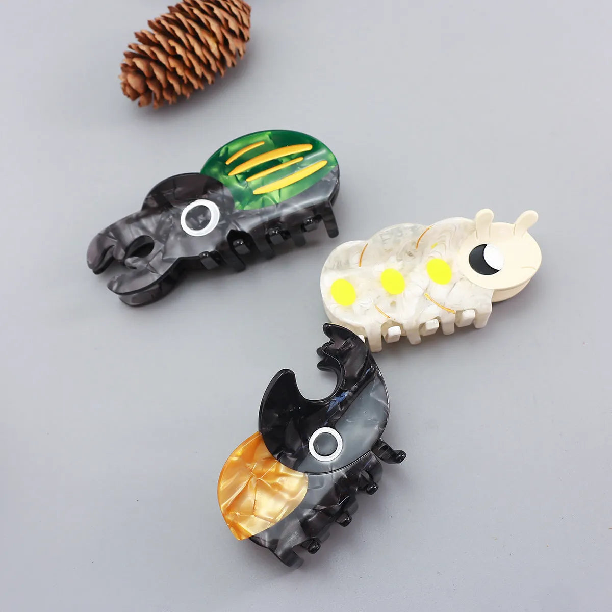 Handmade green and orange cellulose acetate beetle grip with white caterpillar cartoon design